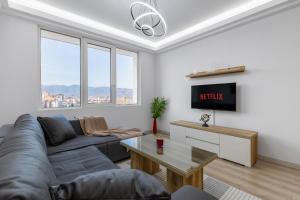 a living room with a couch and a tv at Cevahir Sky City 2BR Family APT, Fitness & Spa in Skopje