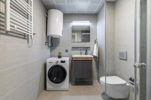 a bathroom with a washing machine and a sink at Cevahir Sky City 2BR Family APT, Fitness & Spa in Skopje +9 photos
