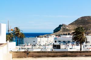 biały budynek z palmami i oceanem w obiekcie Apartamento Del Mar Las Negras w mieście Las Negras