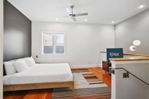 a white bedroom with a bed and a window at Roami at Factors Row in New Orleans