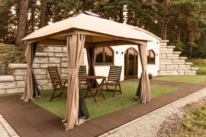 TreimaniKotkapesa的凉亭配有椅子和桌子,位于草地上