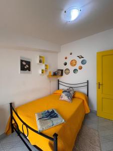 a bedroom with a yellow bed with a yellow blanket at La Mansarda in Marina di Gioiosa Ionica