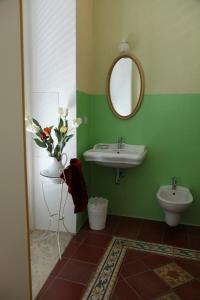 コラートにあるLocus Amoenus Luxury Roomsのバスルーム(洗面台、トイレ、鏡付)