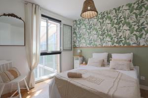 a bedroom with two beds and a large window at Villa Les Agapanthes in Paimpol