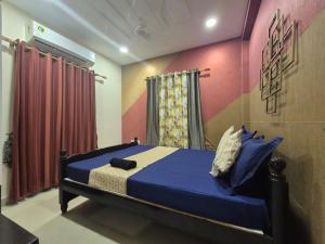 a bedroom with a bed with blue sheets and red walls at Dhuki beach paradise in Chennai