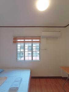 een witte kamer met een bed en een raam bij JeSa's Serenity Sanctuary in Dasmariñas