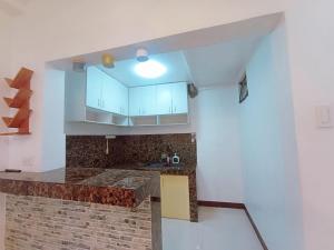 een keuken met witte kasten en een bakstenen muur bij JeSa's Serenity Sanctuary in Dasmariñas +11 foto's