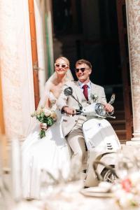 a bride and groom riding on a scooter at Casa Ferrari in Varenna