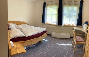 a bedroom with a bed and a desk and a window at Ferienhaus Fuchsbau Hohentauern in Hohentauern