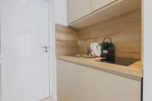 een keuken met witte kasten en een spoelbak bij Studio cosy - 2P - Bercy in Parijs