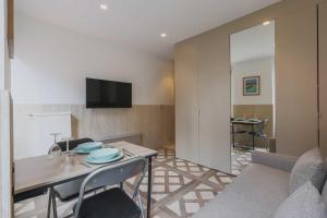 een woonkamer met een tafel en een tv aan de muur bij Studio cosy - 2P - Bercy in Parijs