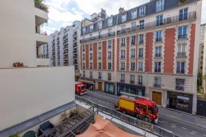 Twee brandweerwagens op een stadsstraat met gebouwen. bij Studio cosy - 2P - Bercy in Parijs