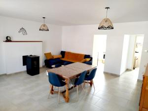 a living room with a table and blue chairs at Les Riderées in Saint-Gervais-du-Perron