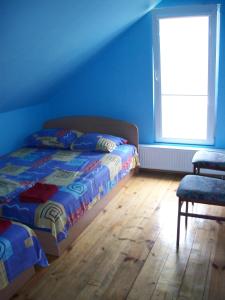 a bedroom with a bed and a window and a chair at Apartamentai in Mažonai
