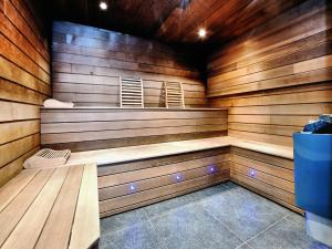 una sauna con paredes revestidas de madera y un banco en Villa with heated outdoor pool and sauna, en Manhay