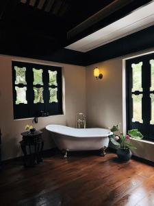 a large bathroom with a tub and two windows at 涤心龙井 in Hangzhou +63 photos