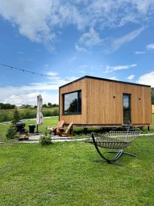 ein kleines Holzhaus auf einem Grasfeld in der Unterkunft глемпінг Обійми in Yatski