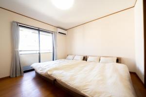 a bed in a room with a large window at rinne 熱海 Retreat in Atami
