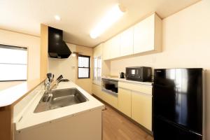 a kitchen with a sink and a black refrigerator at rinne 熱海 Retreat in Atami +16 photos