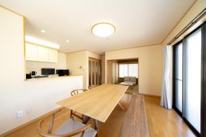 a kitchen and dining room with a wooden table and chairs at rinne 熱海 Retreat in Atami