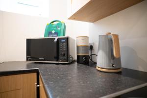 a kitchen counter with a microwave and a coffee maker at Taigh Mor in Elgin