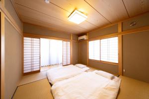 two beds in a room with two windows at rinne 熱海 Retreat in Atami