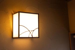 a light on a wall with a window at rinne 熱海 Retreat in Atami