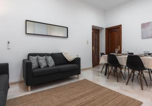 ein Wohnzimmer mit einer Couch und einem Tisch mit Stühlen in der Unterkunft Home4u Castañeda 1º in Granada + 22 Fotos