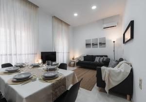 ein Wohnzimmer mit Tisch und Couch in der Unterkunft Home4u Castañeda 1º in Granada