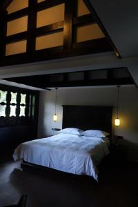 a bedroom with a large bed with white sheets at 涤心龙井 in Hangzhou