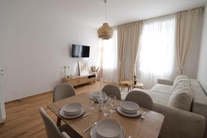 a living room with a table and a couch at Apartment Grace Family in Vienna