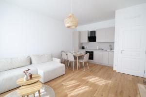 a white living room with a white couch and a table at Apartment Grace Family in Vienna