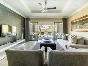 a living room with two chairs and a couch at Shepherds Tree Game Reserve in Pilanesberg