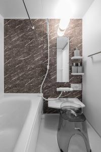 a bathroom with a tub and a sink and a mirror at Furano Resort Wakaba D in Furano