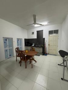 un soggiorno con tavolo e sedie in legno di Homestay Kita Kg Bechah Keranji a Ketereh