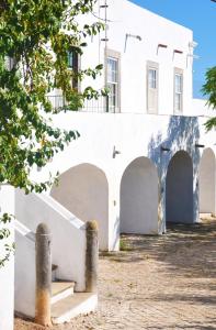 un edificio blanco con arcos y escaleras delante en Casa18.55 - Time with history, en São Brás de Alportel