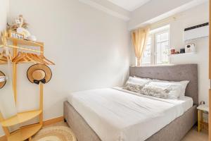a bedroom with a bed with white sheets and a window at 2BR FULLY FURNISHED Trees Residences Near SM Fairview with NETFLIX AND KARAOKE in Manila