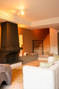 a living room with a white couch and a fireplace at Casa Estelle - cozy with lovely garden - Mijas - Riviera del Sol in Mijas Costa +42 photos