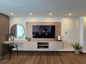 a living room with a television and a mirror at Moderna suite con balcón a pasos de la playa in Cartagena de Indias