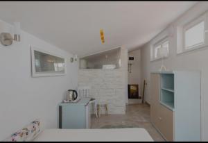 a room with a bed and a kitchen with a table at Brela SP small loft-no parking in Brela
