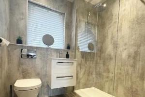 a bathroom with a toilet and a glass shower at 2-Beds Sleeps 4 w Parking 15 mins to St Andrews in Anstruther +3 photos