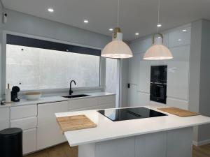 una cucina bianca con mobili bianchi e un lavello di Sun Temple by Madeira Holiday Rentals a Ribeira Brava
