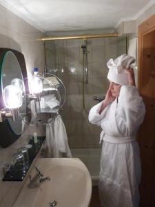 kobieta w szlafroku stojąca w łazience w obiekcie Hotel Gasthof Islitzer w mieście Prägraten +37 zdjęć