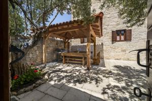 a wooden pergola with a bench in front of a building at Villa Laurana ZadarVillas in Pakoštane