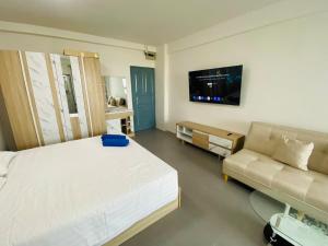 a bedroom with a large bed and a couch at 9 Karat Condo by PSR in Pattaya Central
