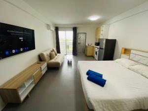 a bedroom with a large bed and a tv at 9 Karat Condo by PSR in Pattaya Central +11 photos