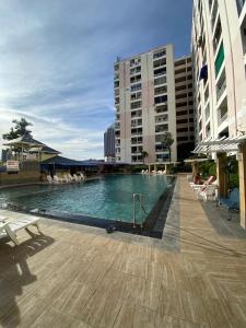 a large swimming pool in a city with buildings at 9 Karat Condo by PSR in Pattaya Central