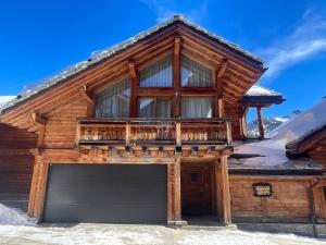 a log house with a garage in the snow at TETRAS Chalet de prestige, 12 personnes , Pieds des pistes in Vars