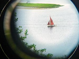 un bateau à voile rouge dans l'eau dans l'établissement Modern Retreat with View - By Traum Ferienwohnungen, à Løgstrup 24 autres photos