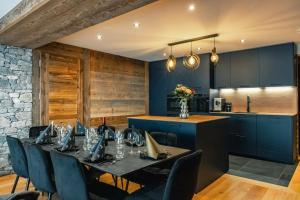 a dining room with a table and chairs and a kitchen at CHALET TEKA LES GETS - Appartement Ubac in Les Gets